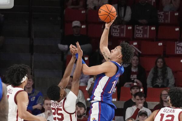Kansas forward Jalen Wilson, right, shoots over Oklahoma guard Grant Sherfield (25) in the second half of an NCAA college basketball game Saturday, Feb. 11, 2023, in Norman, Okla. (AP Photo/Sue Ogrocki)