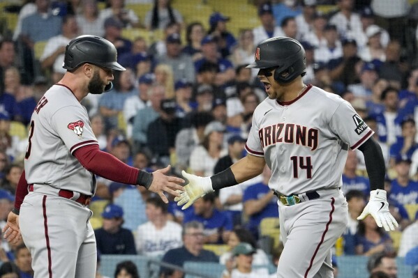 Arizona Diamondbacks' Gabriel Moreno, right, celebrates with teammate Christian Walker after hitting a three-run home run during the first inning in Game 1 of a baseball NL Division Series against the Los Angeles Dodgers, Saturday, Oct. 7, 2023, in Los Angeles. (AP Photo/Mark J. Terrill)