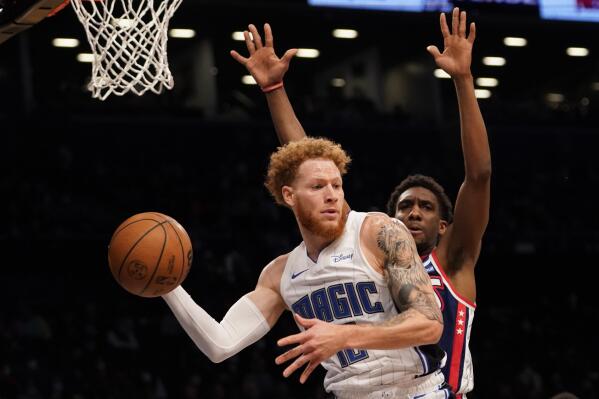 Orlando Magic guard Hassani Gravett (12) moves the ball around Brooklyn Nets guard Langston Galloway during the first half of an NBA basketball game, Saturday, Dec. 18, 2021, in New York. (AP Photo/Mary Altaffer)