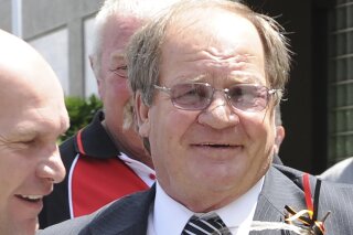 In this Dec. 9, 2011, photo, former rugby league player Tommy Raudonikis with Alan Langer, left, arrives at Artie Beetson's funeral at the Redcliffe Leagues Club, north of Brisbane, Australia. Raudonikis, one of the toughest players to have ever pulled on a rugby league jumper in Australia and one of the game's greatest characters, has died Wednesday, April 7, 2021 of cancer. He was 70. (Dave Hunt/AAP Image via AP)