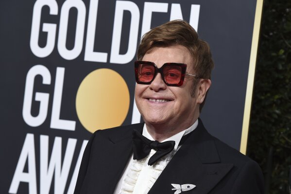 FILE - In a Sunday, Jan. 5, 2020 file photo, Elton John arrives at the 77th annual Golden Globe Awards at the Beverly Hilton Hotel, in Beverly Hills, Calif. Celebrities from Elton John to Chris Hemsworth have each pledged to donate a million to help aid the efforts for the engulfing wildfires in Australia. (Photo by Jordan Strauss/Invision/AP, File)