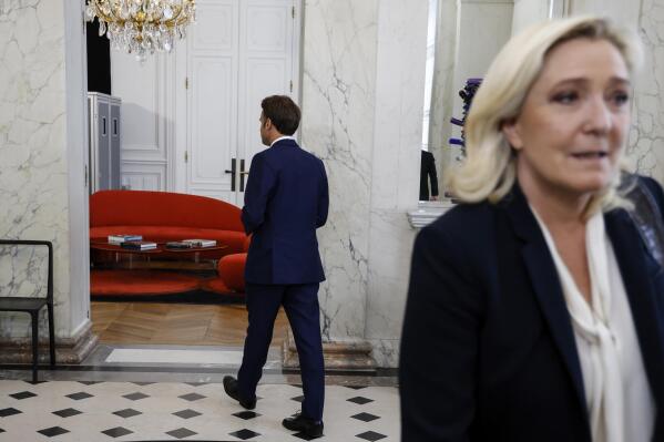 French President Emmanuel Macron, leaves, after a meeting with French far-right Rassemblement National (RN) leader and Member of Parliament Marine Le Pen at the Elysee Palace in Paris, France, Tuesday, June 21, 2022. French President Emmanuel Macron was holding talks Tuesday with France's main party leaders after his centrist alliance failed to win an absolute majority in parliamentary elections. (Ludovic Marin/Pool photo via AP)