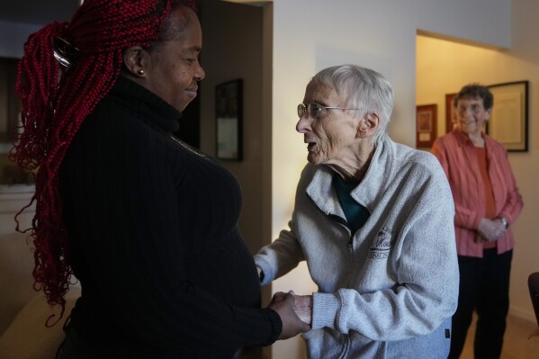Zuleika, an immigrant from Central America seeking asylum, visits Sister Pat Murphy, 95, center, and Sister JoAnn Persch, right, 90, at their home in Alsip, Ill. (AP Photo/Erin Hooley)