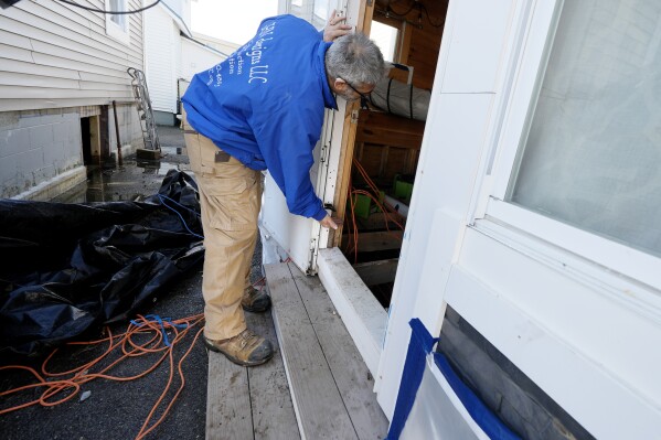 Haim Levy shows the sea water level from January 2024 storms at his cottage near Hampton Beach, Friday, Feb. 9, 2024, in Hampton, N.H. Scientists say the back-to-back storms that lashed the Northeast in January were more of a sign of things to come than an anomaly. Many scientists who study the intersection of climate change, flooding, winter storms and sea level say such storms will arrive with increased frequency and ferocity. (AP Photo/Charles Krupa)