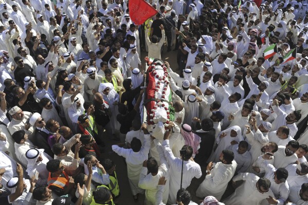 FILE - Thousands of Sunnis and Shiites from across the country take part in a mass funeral procession for 27 people killed in a suicide bombing, at the Grand Mosque in Kuwait City, Kuwait, on June 27, 2015. Kuwait said Thursday, July 27, 2023, it executed five prisoners, including an inmate convicted over the Islamic State group-claimed mosque bombing in 2015. (AP Photo, File)