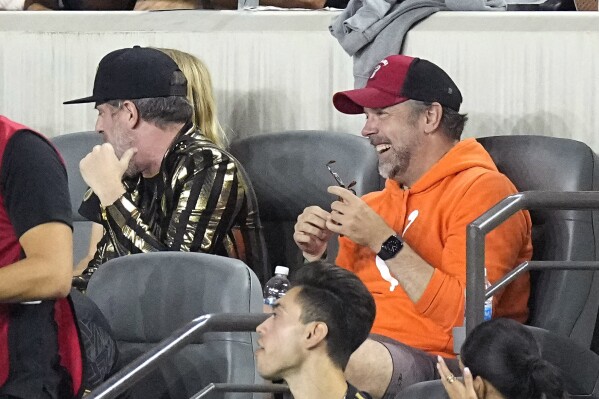 Actor Jason Sudeikis, right, sits with actor Brendan Hunt during the first half of a Major League Soccer match between Los Angeles FC and Inter Miami Sunday, Sept. 3, 2023, in Los Angeles. (AP Photo/Mark J. Terrill)