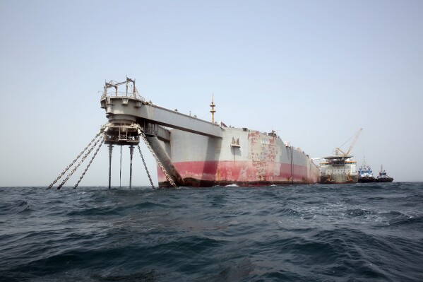 FILE - Technical vessels are seen by the decrepit Safer tanker on Monday, June 12, 2023, off the coast of Yemen. The Safer was built as a tanker and later converted into a floating storage unit. Maintenance on the ship ended in 2015. By 2020, seawater had seeped into the Safer's engine room, corroded pipes and damaged the vessel beyond repair. (AP Photo/Osamah Abdulrahman, File)