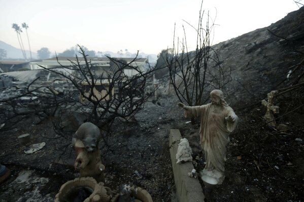 
              A statue sits among destroyed homes in the Rancho Monserate Country Club community Friday, Dec. 8, 2017, in Fallbrook, Calif. The wind-swept blazes have forced tens of thousands of evacuations and destroyed dozens of homes in Southern California. (AP Photo/Gregory Bull)
            