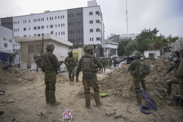 FILE - Israeli soldiers stand outside Shifa Hospital in Gaza City, Wednesday, Nov. 22, 2023. Ayah al-Wakeel, a lawyer, initially sought shelter at the hospital with her family but fled after an Israeli warning to leave. They returned to the hospital on Nov. 4 but she later texted that she felt unsafe and was going south. Israeli forces breached the hospital on Nov. 13. Al-Wakeel has not been heard from since. (AP Photo/Victor R. Caivano, File)