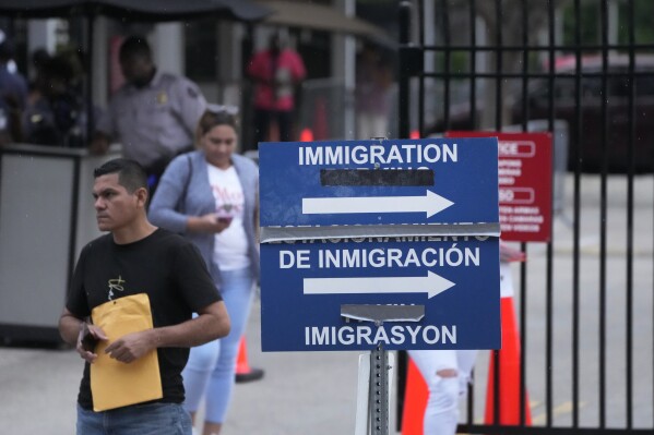 People leave the Immigration and Customs Enforcement (ICE) offices, Wednesday, July 26, 2023, in Miramar, Fla. (AP Photo/Wilfredo Lee)