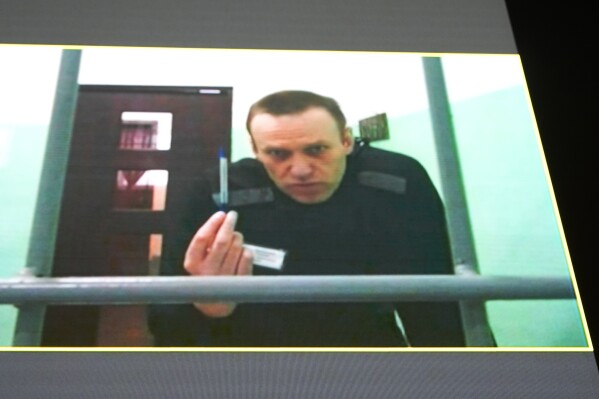 Russian opposition leader Alexei Navalny is seen on a TV screen as he appears in a video link provided by the Russian Federal Penitentiary Service from the colony in Melekhovo, Vladimir region, during a hearing at the Russian Supreme Court in Moscow, Russia, Thursday, June 22, 2023. Navalny has filed a lawsuit contesting prison regulations that, according to him, allow prison officials to deprive him of stationery and pens, thus violating his right to file complaints against them. (AP Photo/Alexander Zemlianichenko)