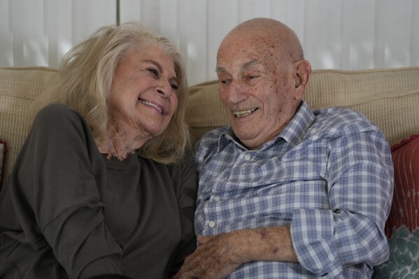 World War II veteran Harold Terens, 100, right, and Jeanne Swerlin, 96, share a laugh as they speak during an interview, Thursday, Feb. 29, 2024, in Boca Raton, Fla. Terens will be honored by France as part of the country's 80th anniversary celebration of D-Day. In addition, the couple will be married on June 8 at a chapel near the beaches where U.S. forces landed. (AP Photo/Wilfredo Lee)