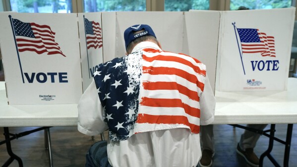 FILE - A patriotic voter sits at a voting kiosk and selects his choices in a party primary in Jackson, Miss., Tuesday, Aug. 8, 2023. Super Tuesday put former President Donald Trump within reach of clinching his third consecutive Republican presidential nomination. But it may be Republican voters in Georgia, Hawaii, Mississippi and Washington who put him over the top. President Joe Biden is also competing in presidential contests that day, but the earliest he can clinch his party's nomination is a week later on March 19. (AP Photo/Rogelio V. Solis, File)