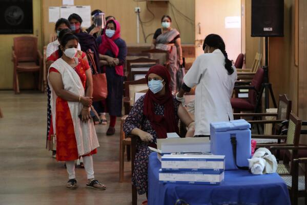 An Indian woman is administered a dose of Covishield, Serum Institute of India’s version of the AstraZeneca vaccine as others wait their turn in Bengaluru, India, Wednesday, May 19, 2021. India has the second-highest coronavirus caseload after the U.S. with more than 25 million confirmed infections. (AP Photo/Aijaz Rahi)