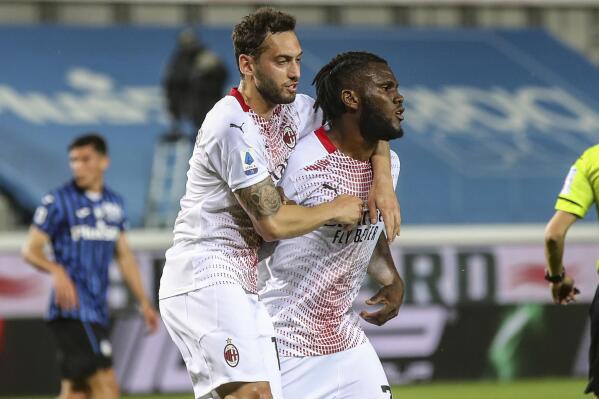 AC Milan's Franck Kessie, right, celebrates with his teammate Hakan Calhanoglu after scoring his side's opening goal, during the Serie A soccer match between Atalanta and AC Milan, at the Gewiss stadium in Bergamo, Italy, Sunday, May 23, 2021. (Stefano Nicoli/LaPresse via AP)