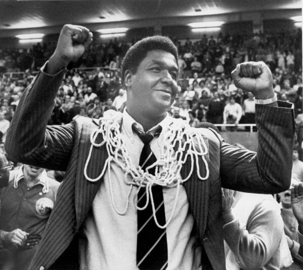 FILE - In this March 1, 1980, file photo, Georgetown University basketball coach John Thompson raises his hands in victory after fans placed the net around his neck in Providence, R.I., after Georgetown defeated Syracuse University 87-81 to win the Big East basketball championship. John Thompson, the imposing Hall of Famer who turned Georgetown into a “Hoya Paranoia” powerhouse and became the first Black coach to lead a team to the NCAA men’s basketball championship, has died. He was 78 His death was announced in a family statement Monday., Aug. 31, 2020. No details were disclosed.(Anestis Diakopoulos/Providence Journal via AP, FIle)