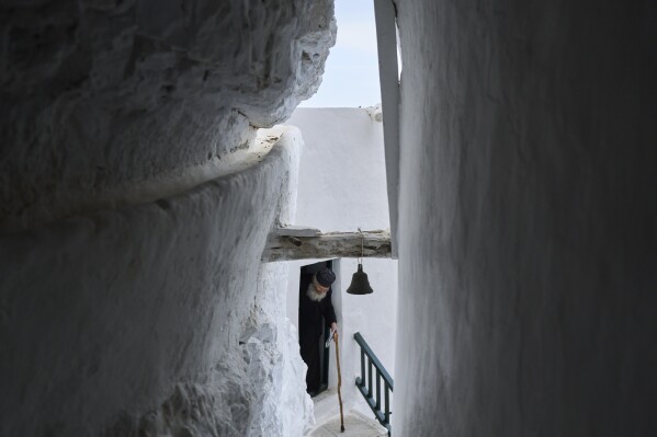 O monge cristão ortodoxo Padre Spyridon de Amorgos sai da capela do Mosteiro de Panagia Hozoviotissa, na ilha de Amorgos, Grécia, quinta-feira, 27 de março de 2025. (Foto AP/Petros Giannakouris)