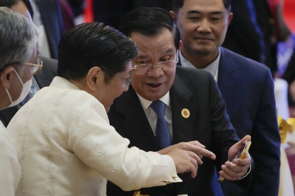FILE -Cambodia Prime Minister Hun Sen, right, shows a mobile device to Philippine's President Ferdinand Marcos, Jr., during the ASEAN - South Korea Summits (Association of Southeast Asian Nations) in Phnom Penh, Cambodia, Friday, Nov. 11, 2022. Cambodia’s Prime Minister Hun Sen, a devoted and very active user of Facebook, says he will no longer upload to the platform, and instead depend on the Telegram app for getting his message across. (AP Photo/Anupam Nath, File)