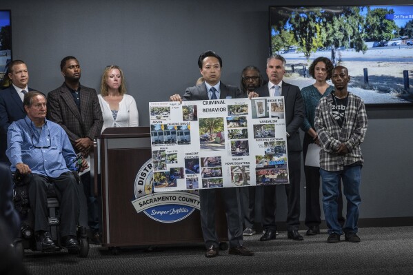 Sacramento County District Attorney Thien Ho holds a poster collage titled "criminal behavior" as he announces on Tuesday, Sept. 19, 2023, that his office is suing the city of Sacramento for creating a public nuisance by failing to take stronger action on homeless camps. A Sacramento prosecutor is suing California's capital city over failure to clean up homeless encampments. Sacramento District Attorney Thien Ho says his office asked the city to enforce laws around sidewalk obstruction and to create additional professionally operated camping sites. (Hector Amezcua/The Sacramento Bee via AP)