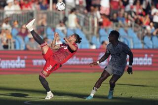 Toronto FC defender Carlos Salcedo (3) plays the ball over his head as CF Montréal forward Romell Quioto (30) looks on during the first half of a semifinal for soccer’s Canadian Championship, Wednesday, June 22, 2022, in Toronto. (Nathan Denette/The Canadian Press via AP)