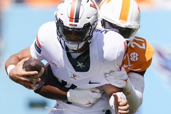 FILE - Tennessee defensive lineman James Pearce Jr., right, sacks Virginia quarterback Tony Muskett, left, in the first half of an NCAA college football game Sept. 2, 2023, in Nashville, Tenn. A report says Pearce was arrested after disobeying police instructions during a traffic stop. According to a Knoxville, Tenn., police report obtained by Knox News, police clocked Pearce driving a 2021 Jeep Grand Cherokee 63 miles per hour in a 35 miles per hour zone. (APPhoto/George Walker IV, File)