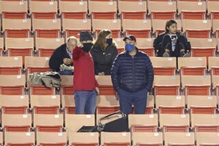 Fans attending the NCAA college football game between Northern Illinois and Buffalo on Wednesday night, Nov. 4, 2020, in DeKalb, Ill., follow guidelines about mask-wearing and social distancing. (Mark Busch/Daily Chronicle via AP)