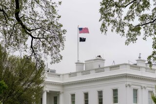 A POW/MIA flag, symbolizing America's Missing in Action and Prisoners of War, flies along with the American flag above the White House, Friday, April 9, 2021, in Washington. (AP Photo/Andrew Harnik)