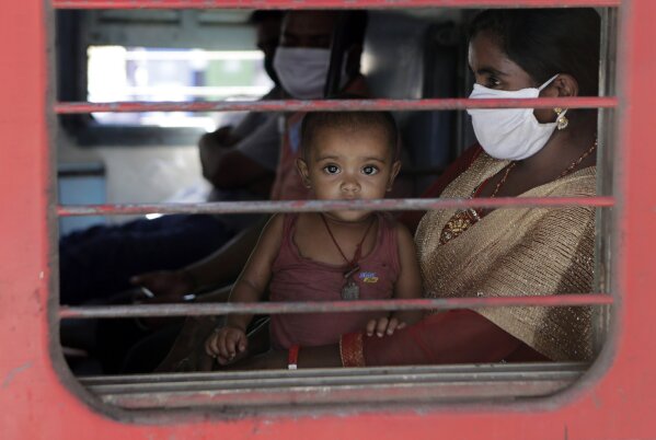 A child looks on as a special train transporting migrant workers to Bihar leaves Thane, in the western Indian state of Maharashtra, Thursday, May 7, 2020. India is running train service for thousands of migrant workers desperate to return home since it imposed a nationwide lockdown to control the spread of the coronavirus. (AP Photo/Rajanish Kakade)