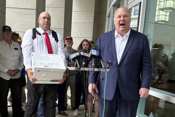 Former Wisconsin Supreme Court Justice Michael Gableman, right, joins with other supporters of former President Donald Trump to deliver petition signatures seeking to recall Republican Assembly Speaker Robin Vos from office, Tuesday, May 28, 2024, in Madison, Wis. (AP Photo/Scott Bauer)