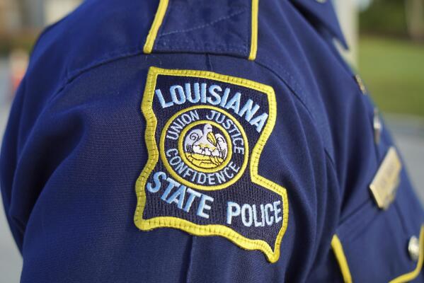 A Louisiana State Police trooper attends the funeral of a colleague in Baton Rouge, La., on Saturday, Oct. 16, 2021. As the Louisiana State Police reel from a sprawling federal investigation into the deadly 2019 arrest of Black motorist Ronald Greene and other beating cases, dozens of current and former troopers tell The Associated Press of an entrenched culture at the agency of impunity, nepotism and in some cases outright racism. (AP Photo/Allen G. Breed)