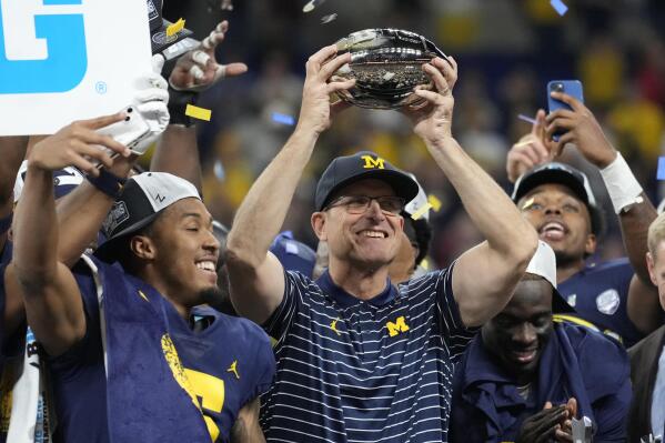 FILE - Michigan head coach Jim Harbaugh holds the trophy as he celebrates with his team after defeating Purdue in the Big Ten championship NCAA college football game, early Sunday, Dec. 4, 2022, in Indianapolis. Michigan is the two-time defending Big Ten champion, and Harbaugh said his 2023 team could be the best he's had since taking over the Wolverines in 2015. (AP Photo/AJ Mast, File)