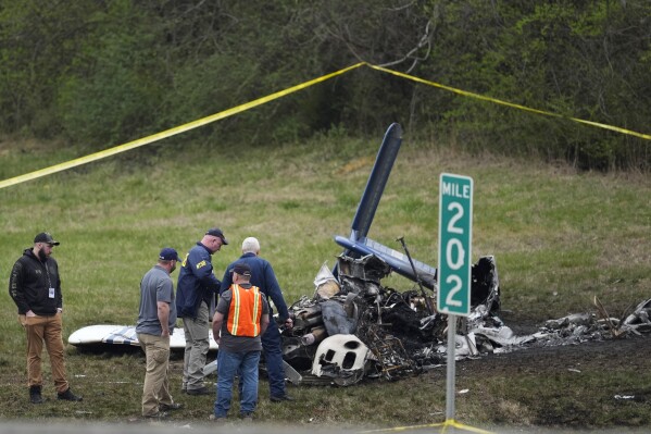FILE - Investigators look over a small plane crash alongside eastbound Interstate 40 at mile marker 202 on Tuesday, March 5, 2024, in Nashville, Tenn. On Thursday, Police have identified those killed in the fiery small plane crash next to Interstate 40 on Monday as a family of five from Canada. (AP Photo/George Walker IV)