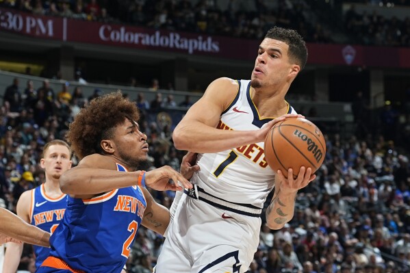 Denver Nuggets forward Michael Porter Jr. (1) drives to the basket as New York Knicks guard Miles McBride defends (2) in the second half of an NBA basketball game Thursday, March 21, 2024, in Denver. (AP Photo/David Zalubowski)