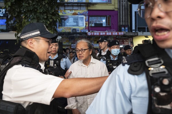 Police officers detain performance artist Sanmu Chen in the Causeway Bay area on the eve of the 35th anniversary of China's Tiananmen Square crackdown in Hong Kong, Monday, June 3, 2024. (AP Photo/Chan Long Hei)