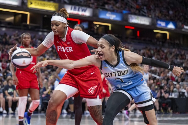 Indiana Fever forward NaLyssa Smith (1) and Chicago Sky guard Chennedy Carter (7) reach for the ball during a WNBA basketball game Saturday, June 1, 2024, in Indianapolis. (AP Photo/Doug McSchooler)