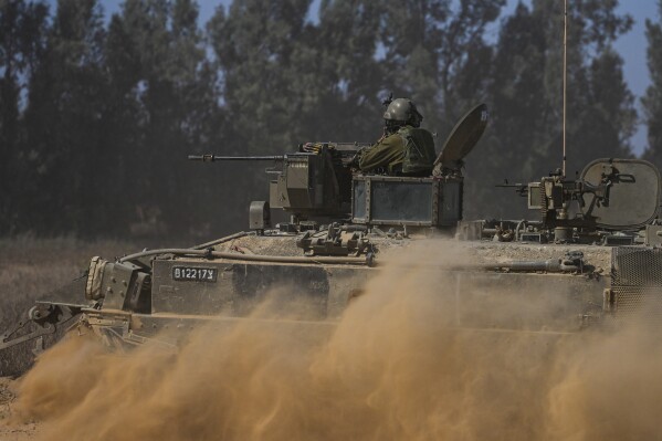 Israeli soldiers drive an APC near the Israeli-Gaza border, in southern Israel, Thursday, May 30, 2024. (AP Photo/Tsafrir Abayov)