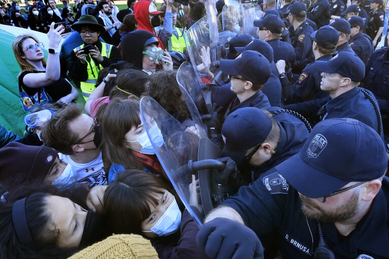 Wis. в сряда, 1 май 2024 г.  Служителите на реда се сблъскват с демонстранти, протестиращи срещу войната в Газа, докато работят за разчистване на незаконен лагер в кампуса на UW-Madison в Медисън.  (AP чрез John Hart/Wisconsin State Journal)