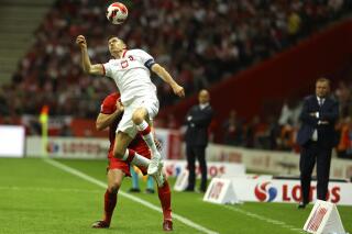 FILE - Poland's Robert Lewandowski heads the ball during the UEFA Nations League soccer match between Poland and Belgium at the National Stadium in Warsaw, Poland, June 14, 2022. Barcelona has made an offer to Bayern Munich for star striker Robert Lewandowski, the Spanish club’s president said Thursday, July 7, 2022. (AP Photo/Michal Dyjuk, File)