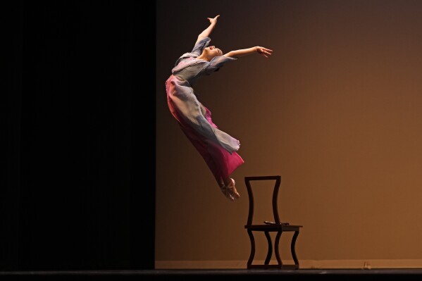 Hailey Zhao leaps from a chair during a ballet performance at the Youth America Grand Prix, Friday, Jan 17, 2025, at the Hanover Theater in Worcester, Mass. (AP Photo/Robert F. Bukaty)