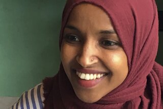 FILE - In this Aug. 16, 2018 file photo, Democrat Ilhan Omar, the nation's first Somali-American legislator who won her party's congressional primary in the race, talks during an interview at Peace Coffee in Minneapolis. Omar, who is poised to become the first Somali-American elected to the U.S. House, has denounced allegations that she married her brother, committed immigration fraud and violated campaign finance laws, calling them “disgusting lies.” (AP Photo/Jeff Baenen, File)