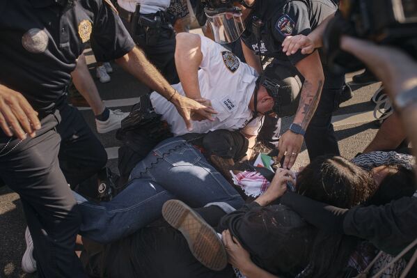 A New York City police officer punches a pro-Palestinian demonstrator as he pins him on the ground during a protest demanding a permanent cease-fire in Gaza, Friday, May 31, 2024, in the Brooklyn borough of New York. (AP Photo/Andres Kudacki)