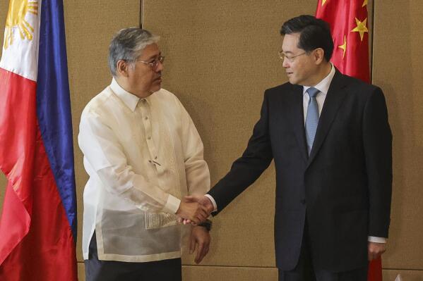 Chinese Foreign Minister Qin Gang, right, and Philippine Foreign Affairs Secretary Enrique Manalo shake hands during the welcome ceremony prior to their bilateral meeting at the Diamond Hotel on Saturday, April 22, 2023, in Manila, Philippines. (Gerard Carreo/Pool Photo via AP)