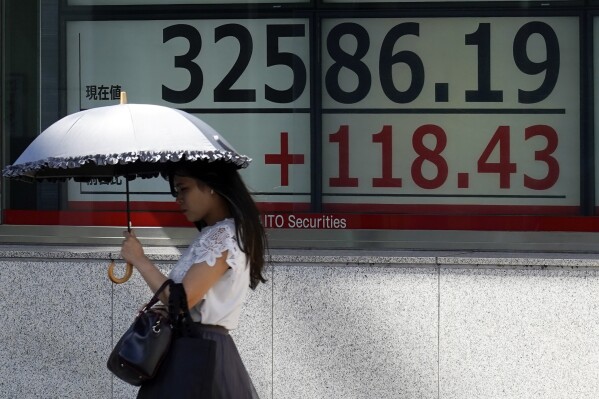 A person walks in front of an electronic stock board showing Japan's Nikkei 225 index at a securities firm Tuesday, Sept. 12, 2023, in Tokyo. Asian shares mostly declined Tuesday despite a Big Tech rally on Wall Street, as investors looked ahead to data on U.S. consumer prices set for later in the week. (AP Photo/Eugene Hoshiko)