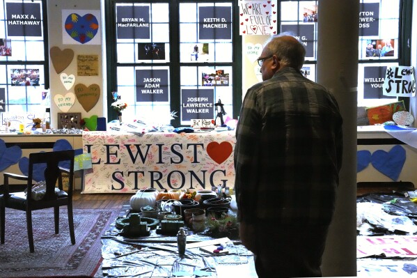 Volunteer Rich Beard looks over archived items, many left at memorials outside Lewiston shooting sites, at the Maine Museum of Innovation, Learning and Labor, Wednesday, Dec. 27, 2023, in Lewiston, Maine. (AP Photo/Charles Krupa)