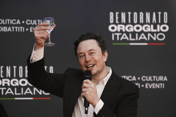 File - Tesla and SpaceX's CEO Elon Musk cheers as he speaks at the annual political festival Atreju, in Rome on Dec. 16, 2023. A recent report from anti-poverty organization Oxfam highlighted how the fortunes of the world's five richest people — Musk, Amazon founder Jeff Bezos, Oracle cofounder Larry Ellison, Bernard Arnault of luxury company LVMH, and investment guru Warren Buffett — have more than doubled since 2020. (AP Photo/Alessandra Tarantino, File)