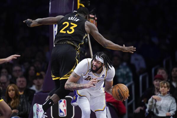 Los Angeles Lakers' Anthony Davis, bottom, is defended by Golden State Warriors' Draymond Green during the second half of an NBA basketball game Sunday, March 5, 2023, in Los Angeles. (AP Photo/Jae C. Hong)
