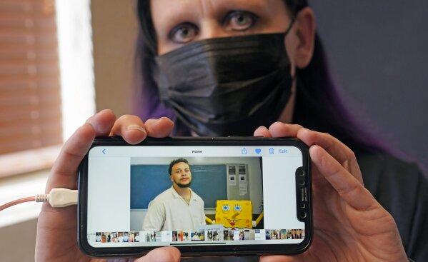 Carrie Shipp shows a photo of her incarcerated 21-year-old son Matthew Shipp that she keep on her cell phone Friday, April 2, 2021, in Irving, Texas. Fewer than 20 percent of state and federal prisoners have received a COVID-19 vaccine, according to data collected by The Marshall Project and The Associated Press. Carrie Shipp said her son decided not to get vaccinated out of fear and distrust of prison medical staff.  (AP Photo/LM Otero)