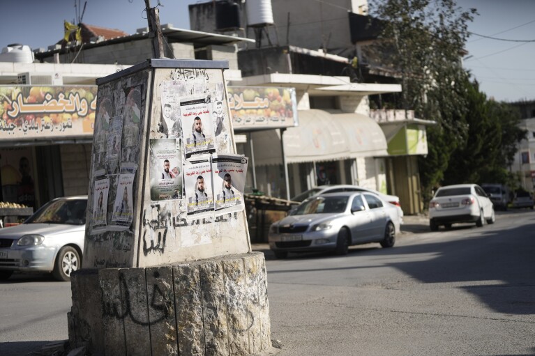 A poster shows Osaid Rimawi, 17, on Sunday, Jan. 7, 2024, two days after he was fatally shot by Israeli forces and two others were wounded in the occupied West Bank village of Beit Rima.  (AP Photo/Mahmoud Illean)