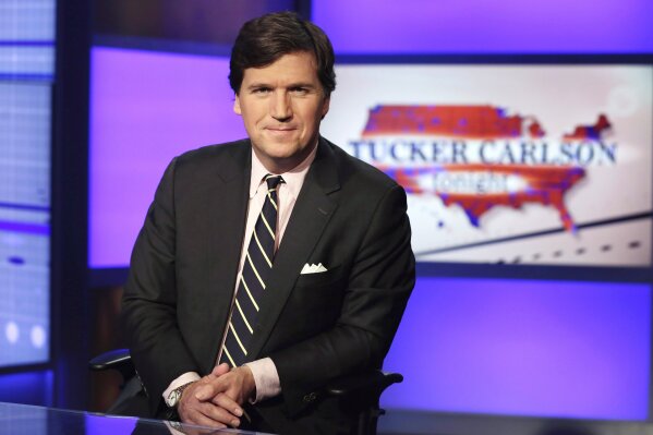 Tucker Carlson, host of "Tucker Carlson Tonight," poses for photos in a Fox News Channel studio, in New York in this March 2, 2017, file photo.  A Manhattan judge has tossed out a defamation lawsuit against Fox News brought by the former Playboy model who took a $150,000 payoff to squelch her story of an affair with Donald Trump. Karen McDougal had alleged in the suit filed late last year that Fox host Tucker Carlson slandered her by calling the payout “a classic case of extortion.” The judge ruled Thursday, Sept. 24, 2020 that the remarks were “rhetorical hyperbole." (AP Photo/Richard Drew, File)