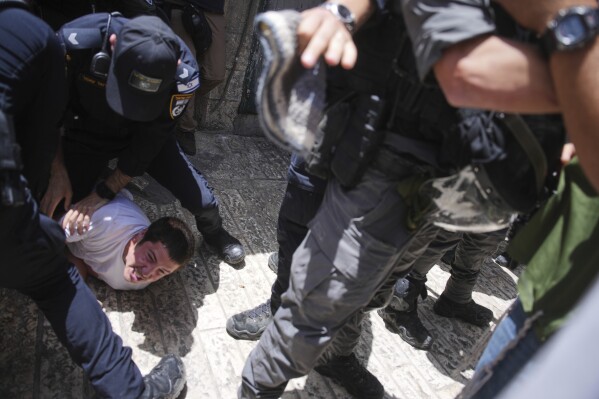 Police scuffle with Israeli youths during a march marking Jerusalem Day, an Israeli holiday celebrating the capture of east Jerusalem in the 1967 Mideast war, in Jerusalem's Old City, Monday, May 26, 2025. (AP Photo/Ohad Zwigenberg)